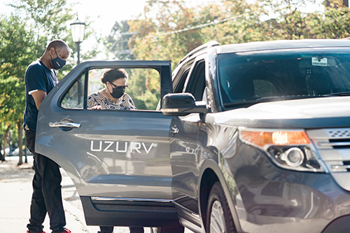 UZURV driver helping female rider into car
