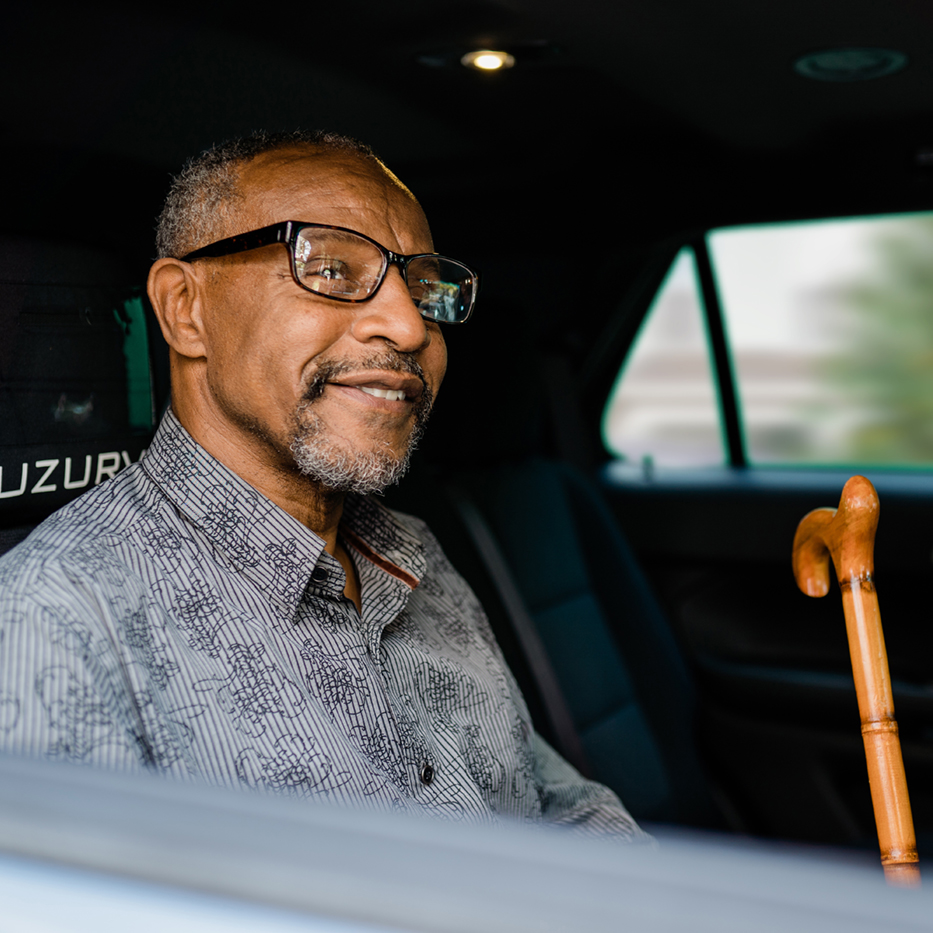 male passenger smiling in backseat of vehicle