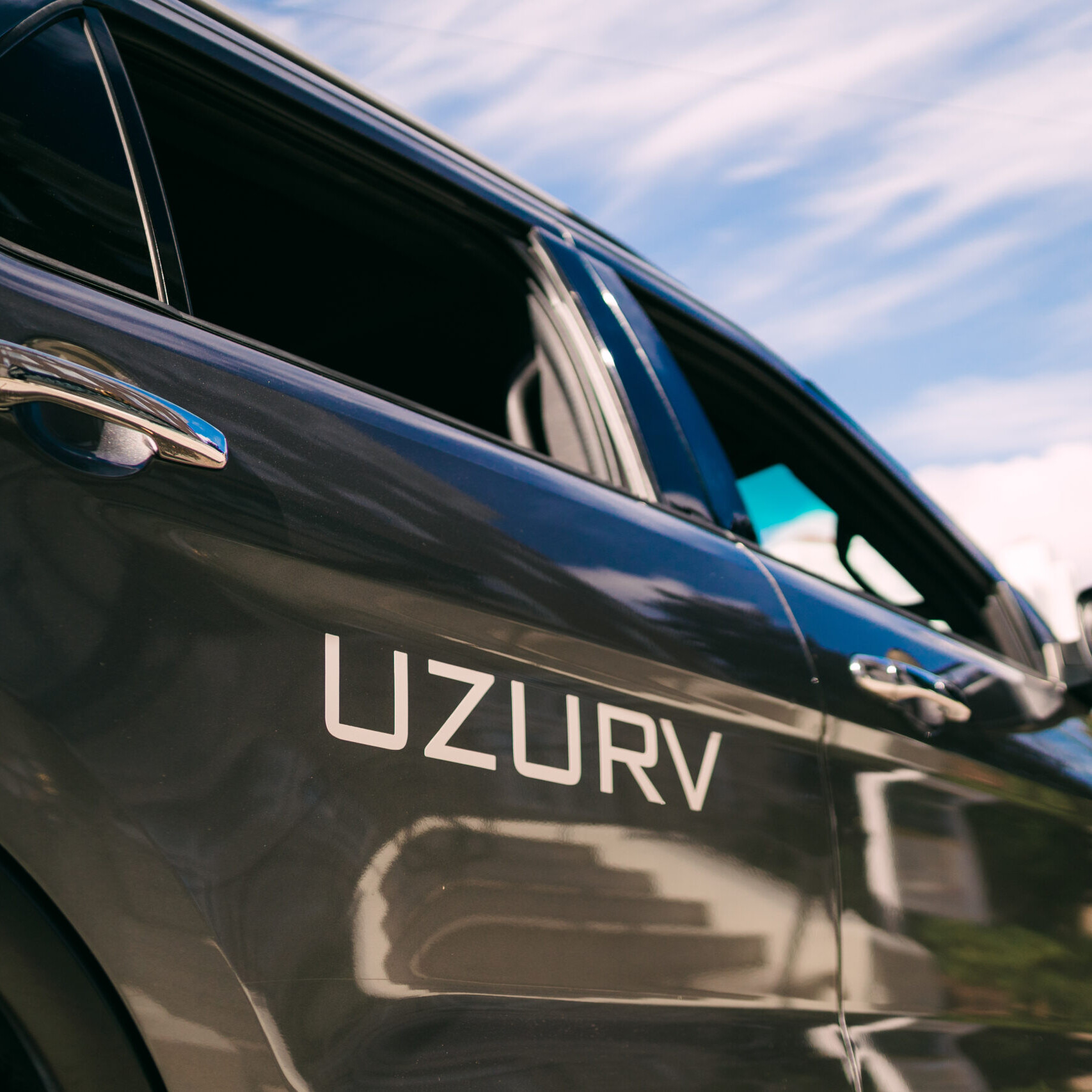 Silver vehicle with the UZURV logo on the back door.