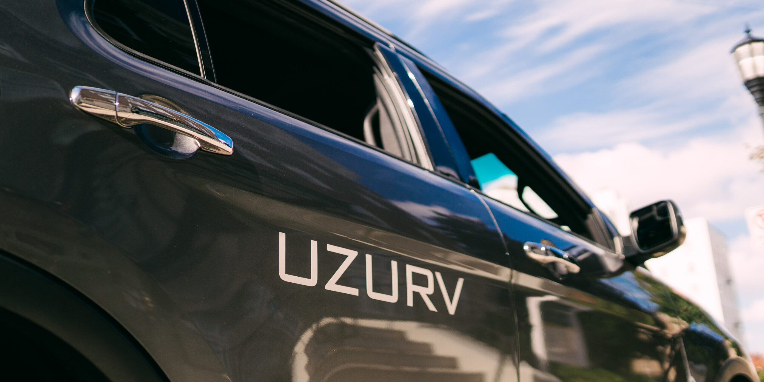 Silver vehicle with the UZURV logo on the back door.
